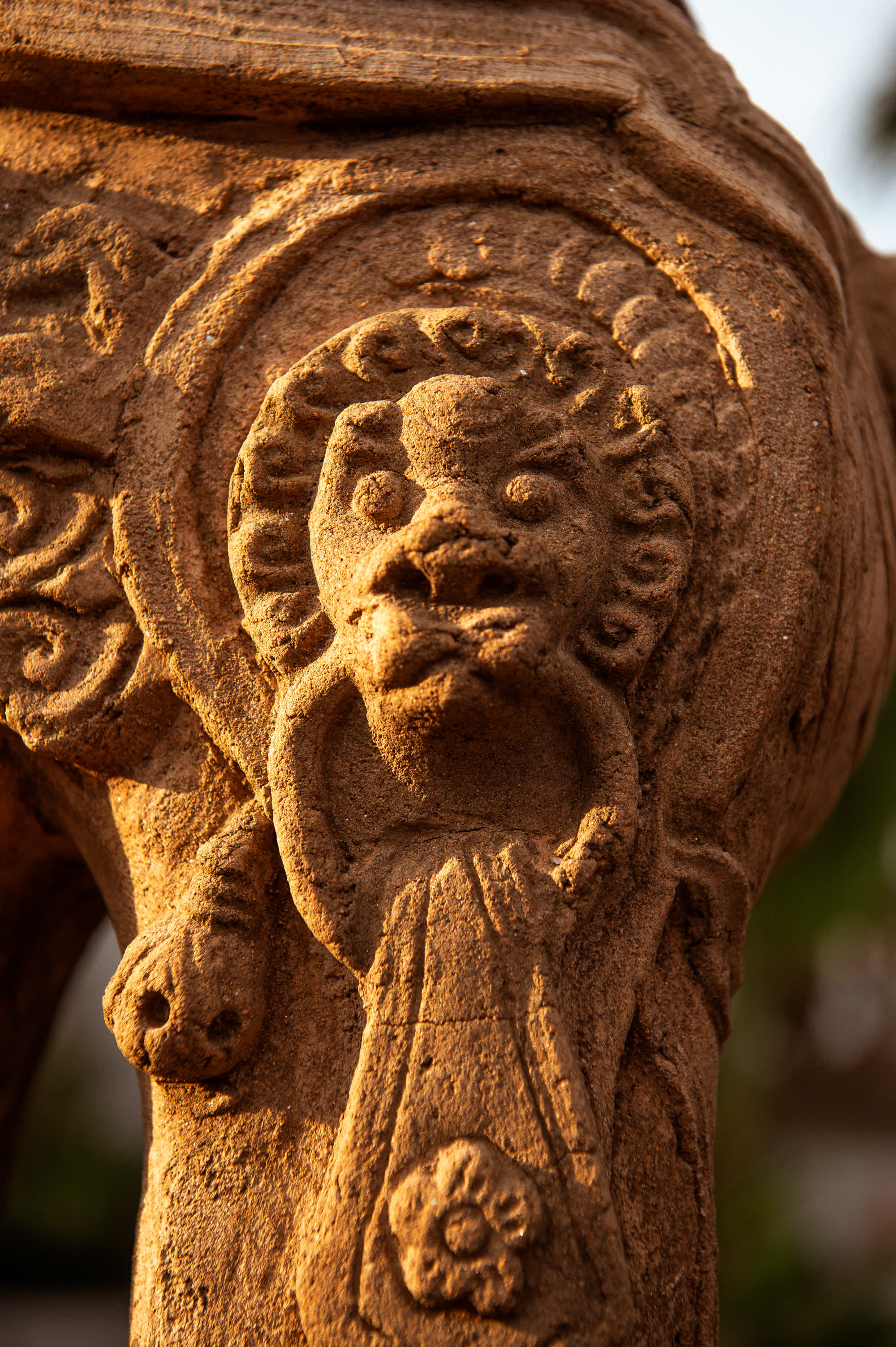 Carved sandstone face of the Nghê, the Vietnamese mythical guardian the hotel is named for