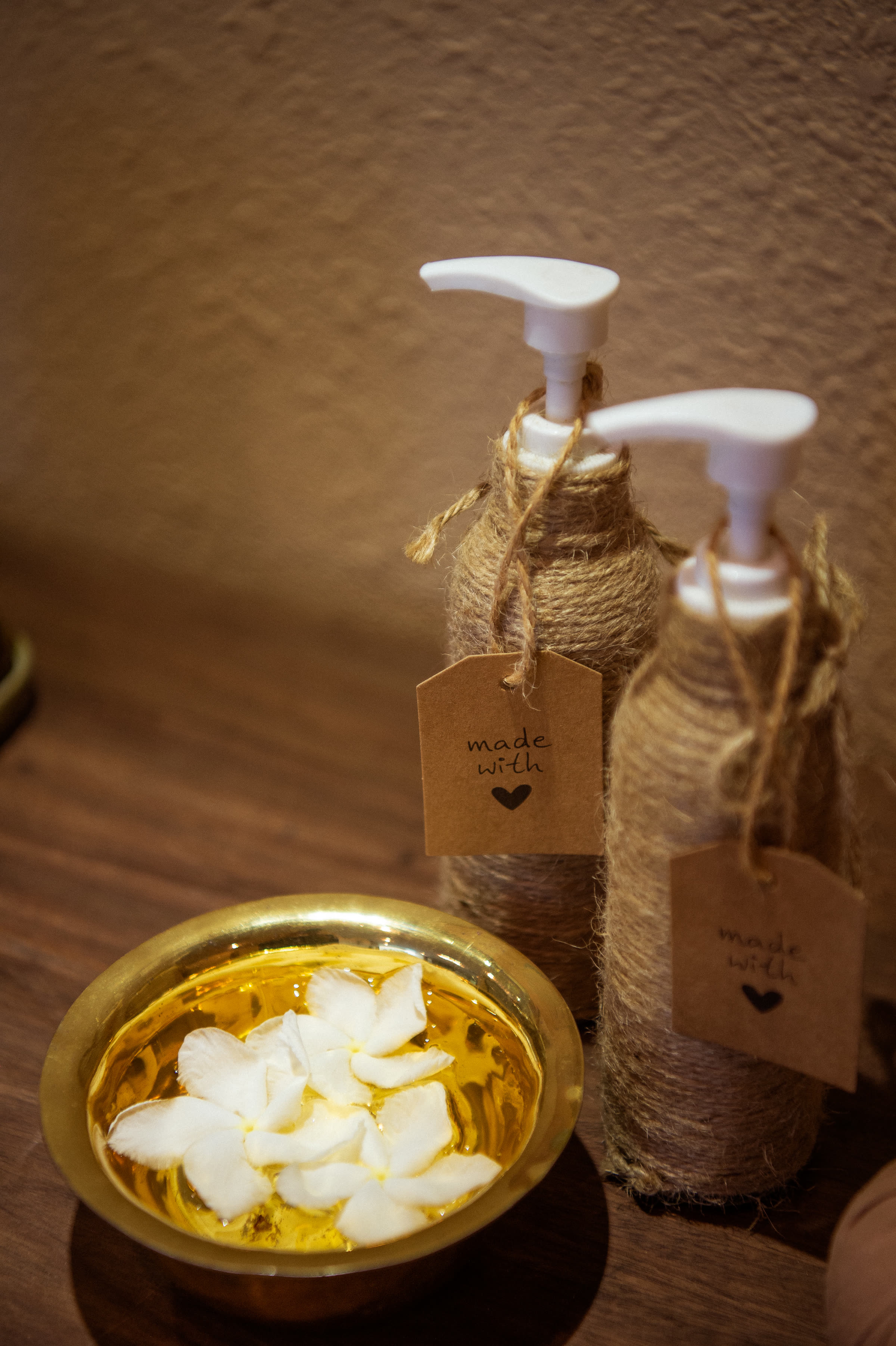 Frangipani flowers in a brass bowl beside the treatment bed at Nghê Prana spa, Hội An