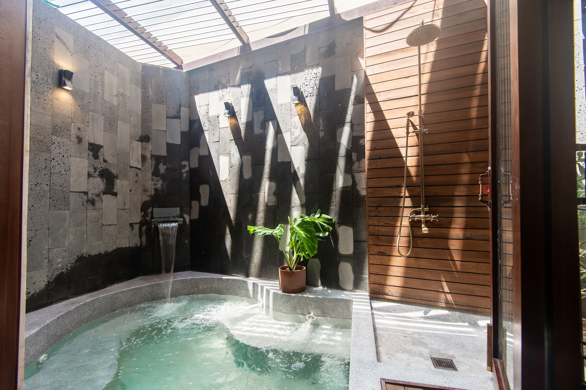 The open-air soaking pool and rain showers in the stone courtyard at Nghê Prana spa
